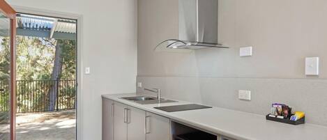 Una cocina moderna con un lavamanos de acero inoxidable, lavavajillas y horno empotrado.