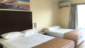 A hotel room with two beds, a painting of a sunset, an air conditioner, and a window with curtains. - Centenary Motor Inn (Oxley)
