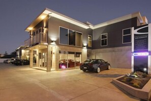 A modern hotel with a two-story structure, a covered entrance, and a parking area with cars. - City Corporate Motor Inn (Palmerston North)