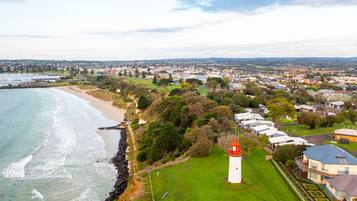 A coastal town with a lighthouse, beach, and residential area.
