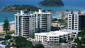 Un hotel costero con varios edificios altos, una playa y una pequeña isla al fondo.