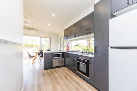 Deluxe Villa, 2 Bedrooms | Private kitchen | Full-size fridge, microwave, stovetop, electric kettle. NRMA Eastern Beach Holiday Park