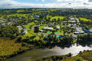 Vista aérea de una zona residencial con casas, un campo de golf y un lago.