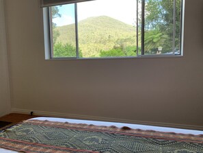 A room with a large window overlooking a green landscape and a patterned rug on the floor. - The Warby (Warburton)