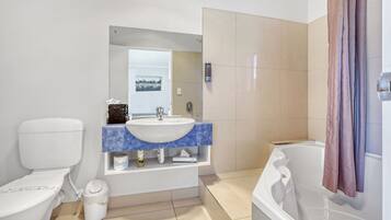 A bathroom with a toilet, sink, and bathtub.