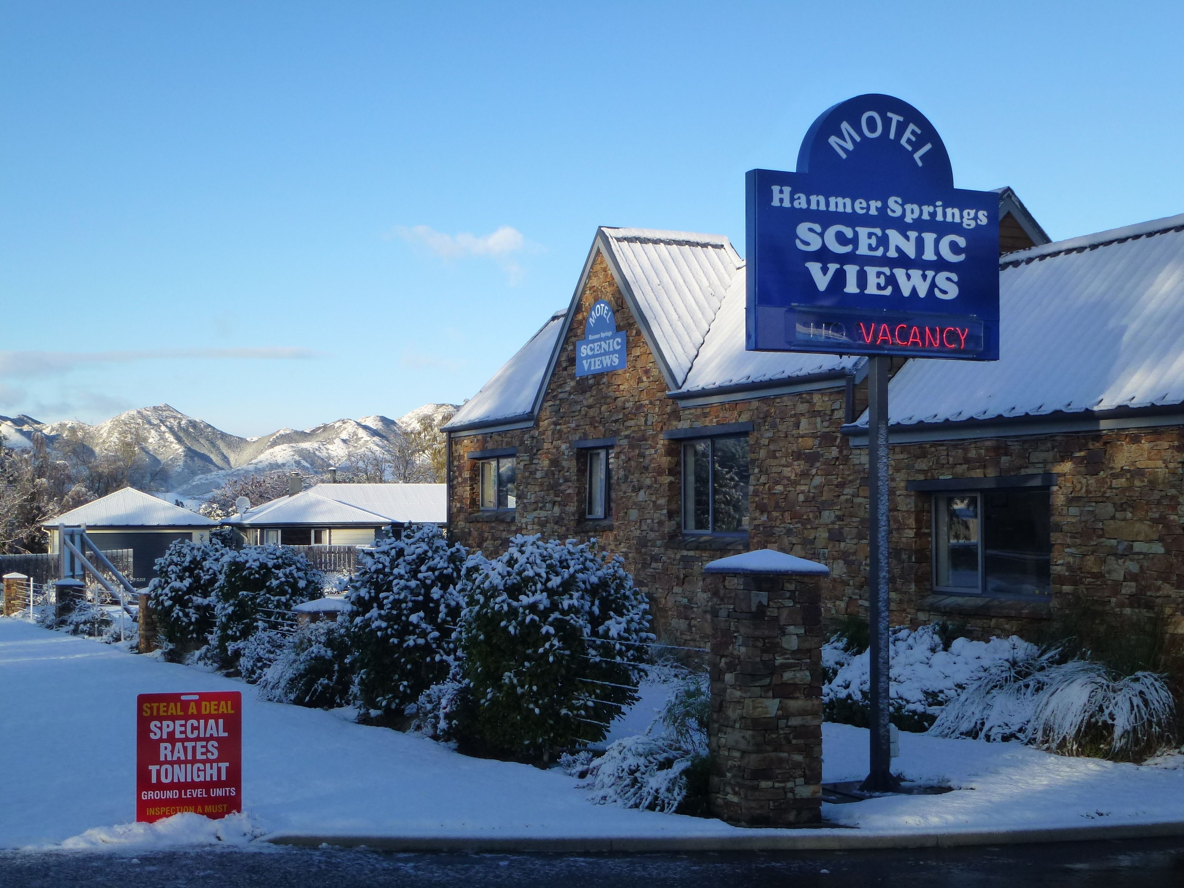 Een motel genaamd 'Hanmer Springs Scenic Views' met een bord dat aangeeft dat er kamers beschikbaar zijn.