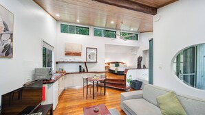 A modern living space with a kitchen, dining area, and a cozy seating area with a sofa and a coffee table. - Hunchy Hideaway (Hunchy)