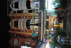 A multi-story building with a restaurant on the ground floor, air conditioning units, and a sign indicating a vacancy. - Karon Sunshine Guesthouse & Bar (Karon)