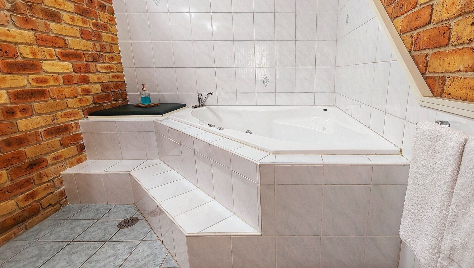 A bathroom with a white bathtub, a sink, and a towel rack.