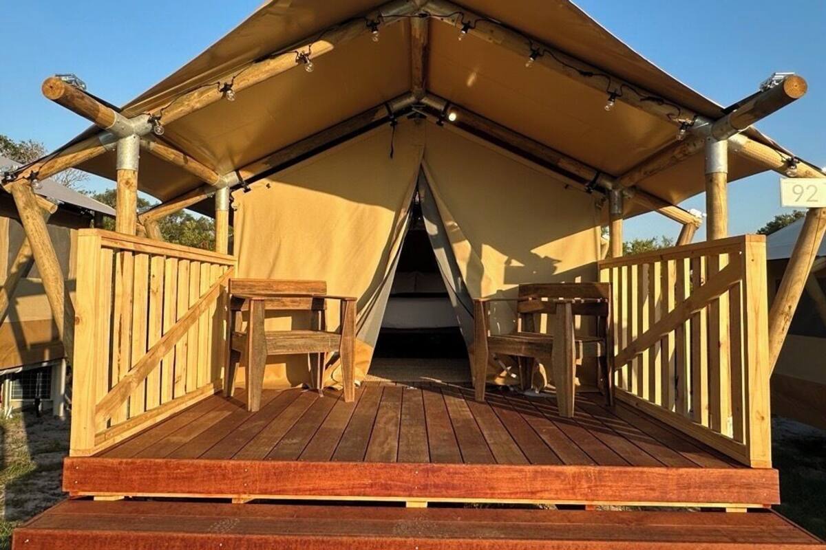 A wooden tent with a platform and seating area.