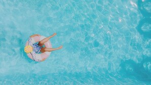 A person floating on a water surface in a pool.