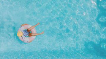 En säsongsöppen utomhuspool, parasoller och solstolar