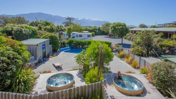 Resort com piscina, banheiras de hidromassagem e vista para as montanhas.