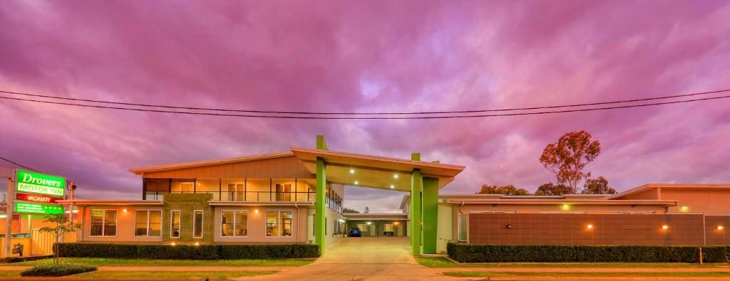 Un motel con entrada techada, zona de estacionamiento visible y un letrero que indica el nombre del motel.