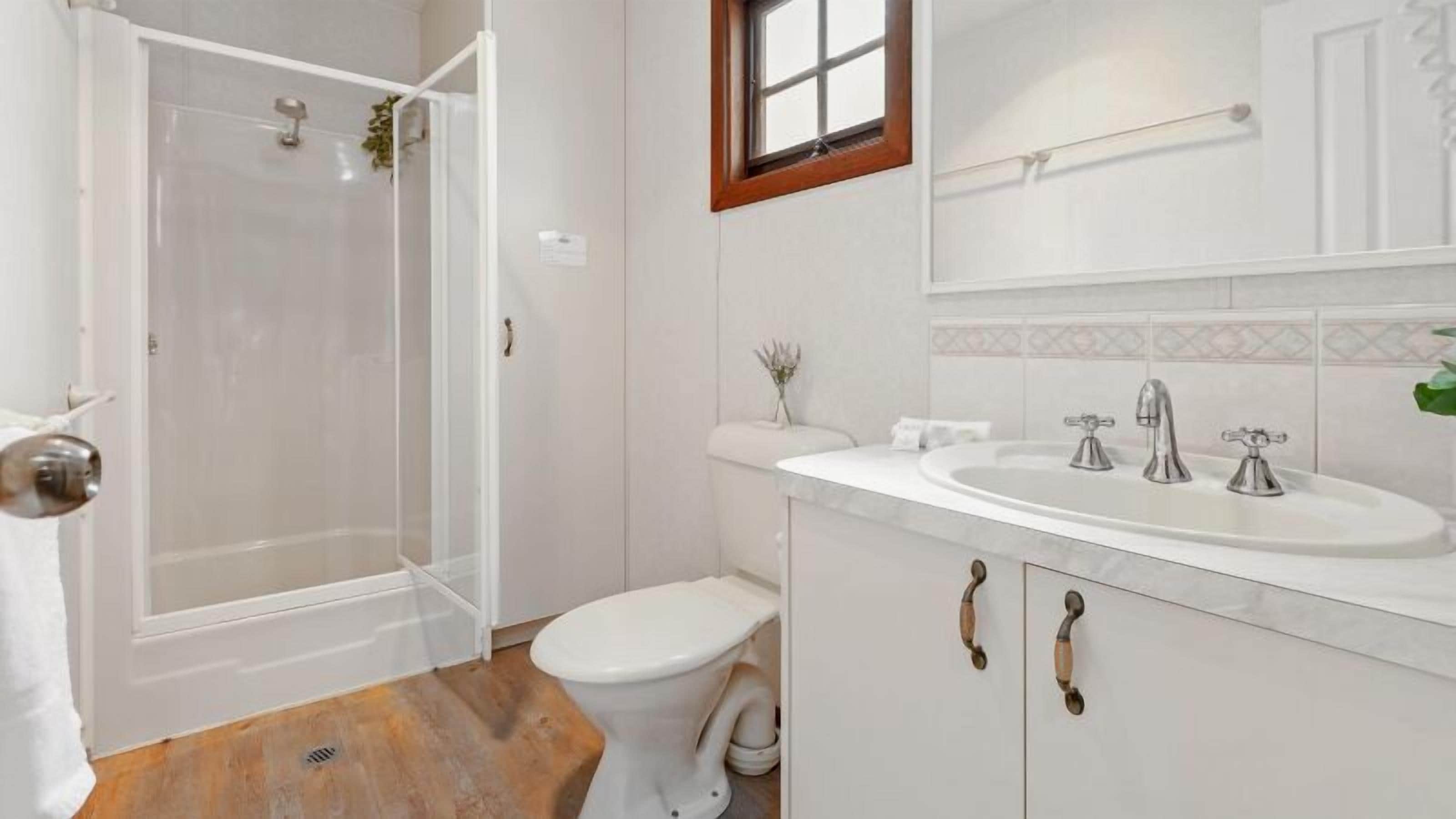 Ein Badezimmer mit Dusche, Toilette, Waschbecken und Waschtisch.