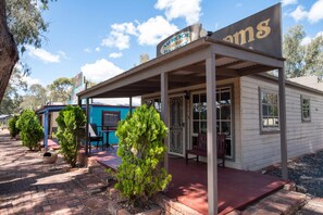 A small, single-story building with a covered porch and a sign reading "Merool Bakery."