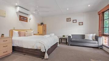 Una habitación de hotel con una cama, un sofá, una mesita y una ventana.
