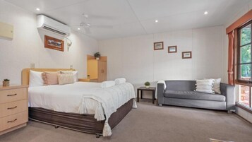 Una habitación de hotel con una cama, un sofá, una mesita y una ventana.