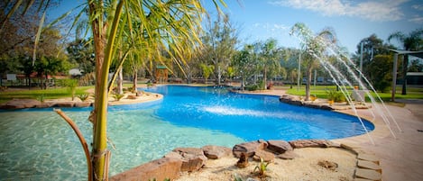 Una piscina al aire libre, sillones reclinables de piscina