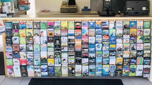A reception desk with a wall of brochures and a welcome mat. - Lighthouse Beach Holiday Village (Port Macquarie)