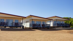 Una hilera de casas móviles de un piso, con porches y barandillas.