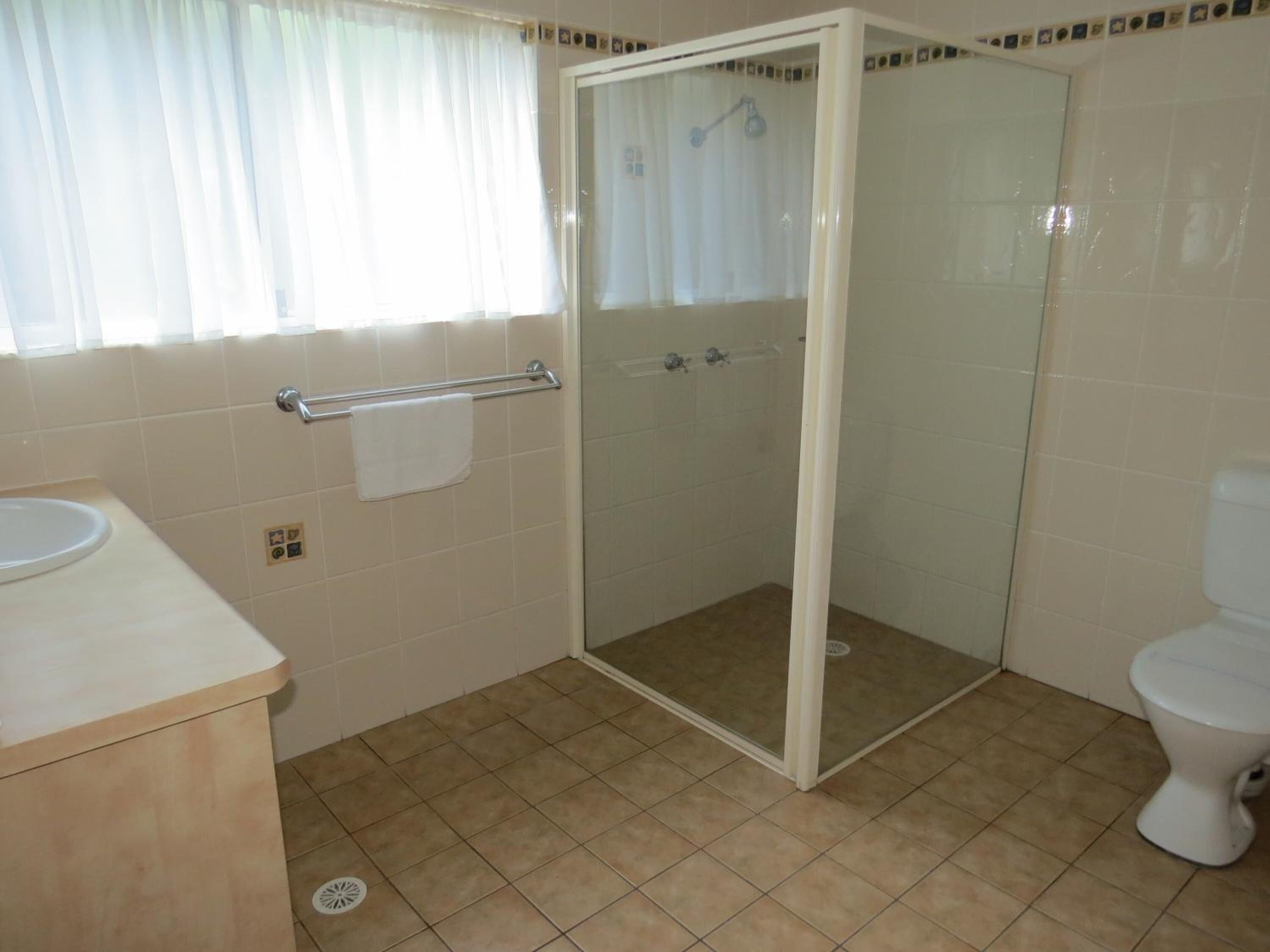 Ein Badezimmer mit Dusche, Toilette und Waschbecken.