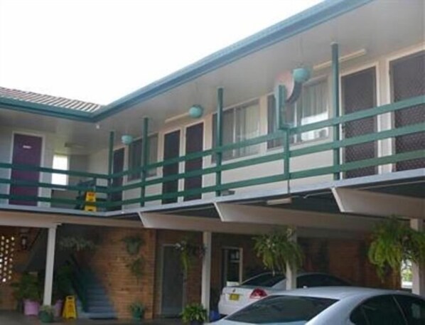 A two-story motel with a covered parking area and multiple rooms.