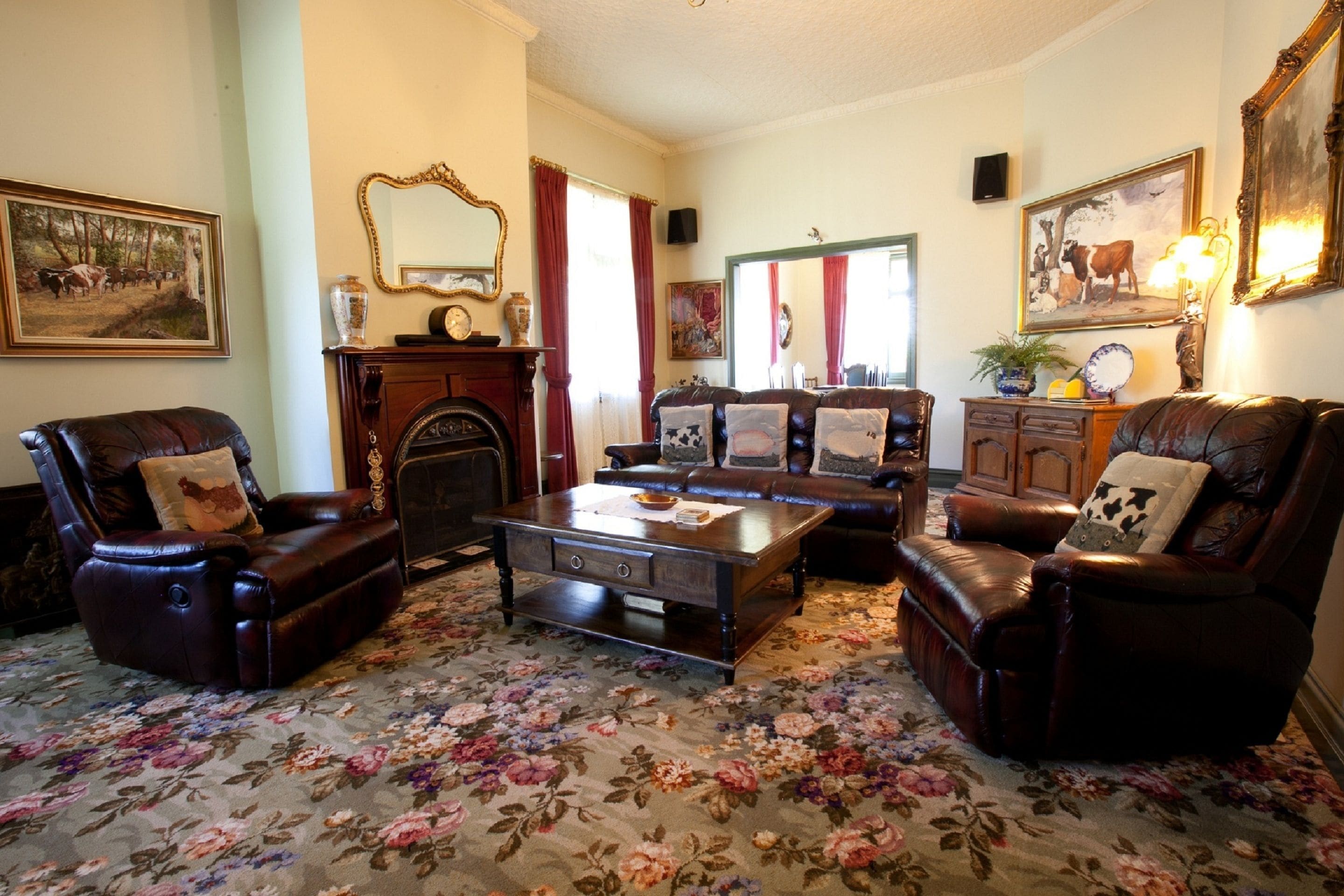 A traditional living room with leather armchairs, a wooden coffee table, and floral carpet.