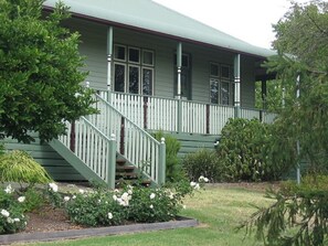 A two-story house with a green exterior, white railings, and a front porch. - Wild Cattle Creek Estate (Seville)