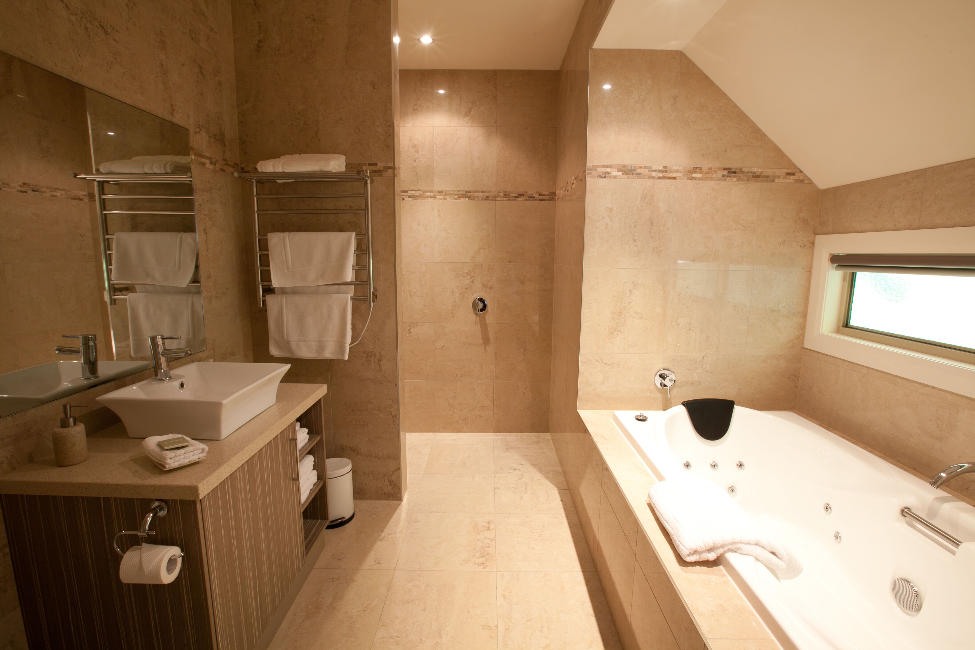 A modern bathroom with a sink, mirror, towel rack, shower, and bathtub.