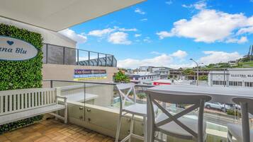 Un balcon avec vue sur la ville, une enseigne pour Cap Coast Home Loans et un banc.