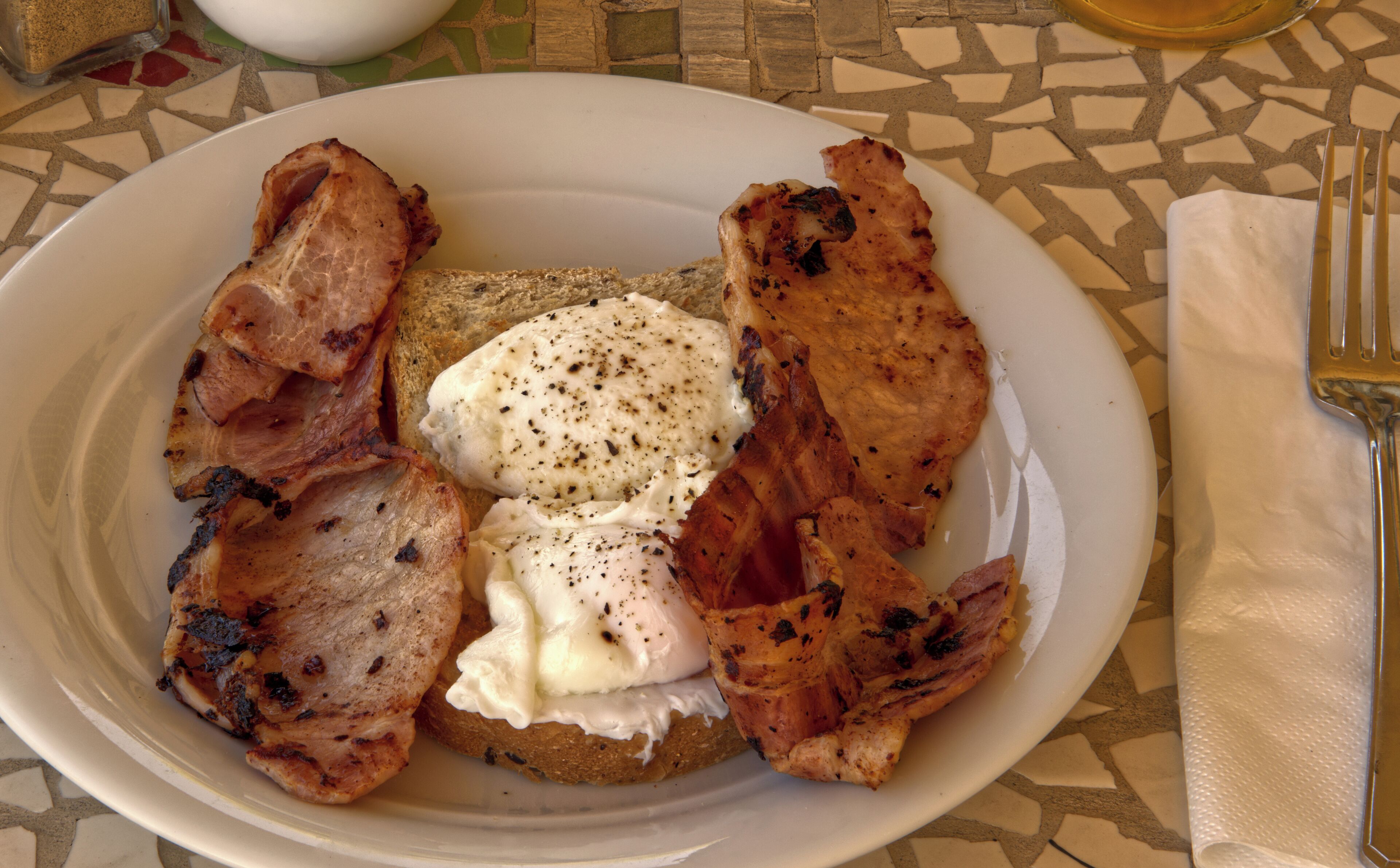 Une assiette avec des toasts, des œufs brouillés et du bacon.