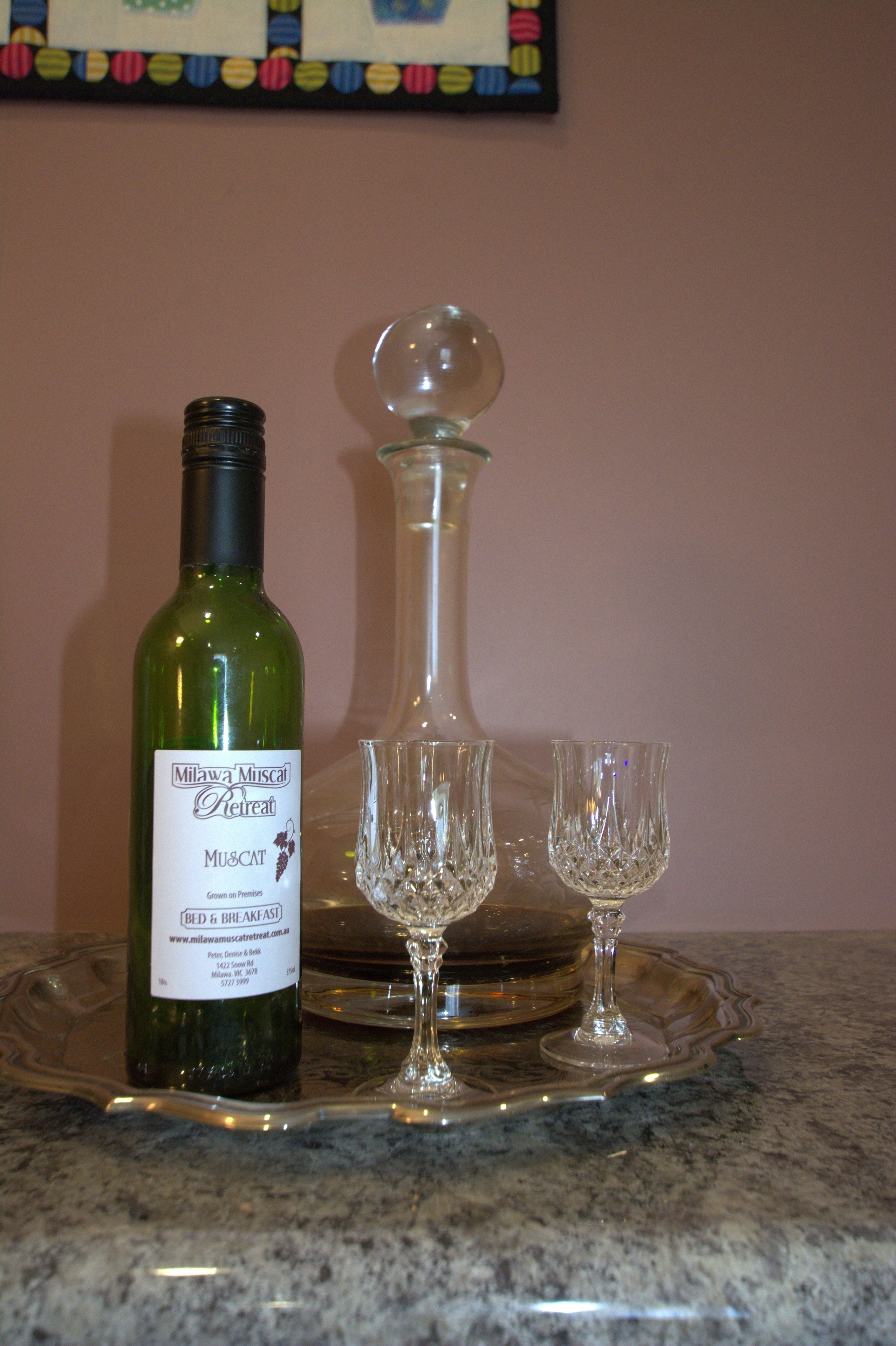 A bottle of wine, a decanter, and two wine glasses on a tray.
