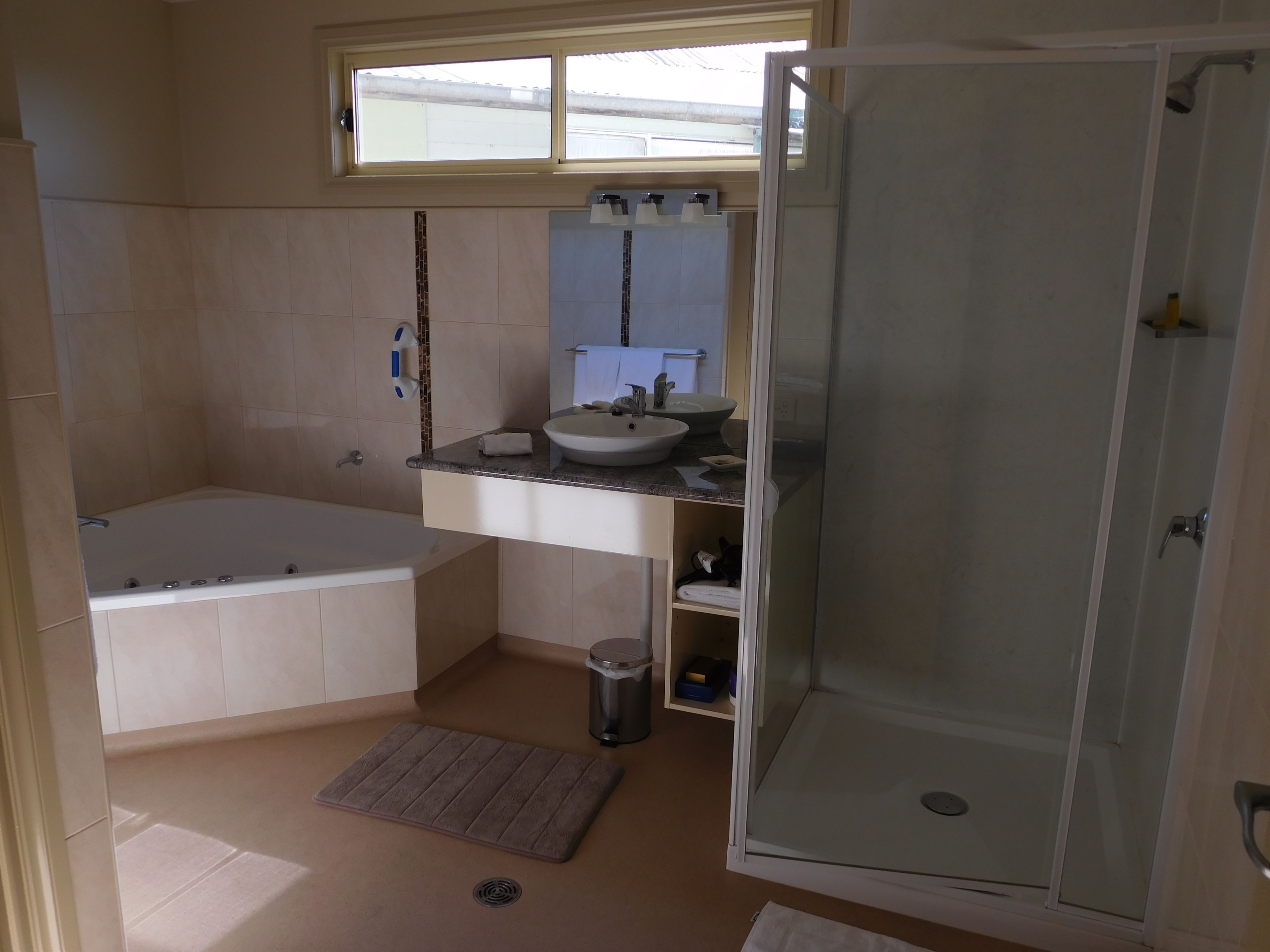A bathroom with a bathtub, a sink, a mirror, and a shower.