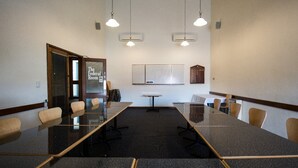 A conference room with a long table, chairs, and a whiteboard. - Black Buffalo Hotel (North Hobart)
