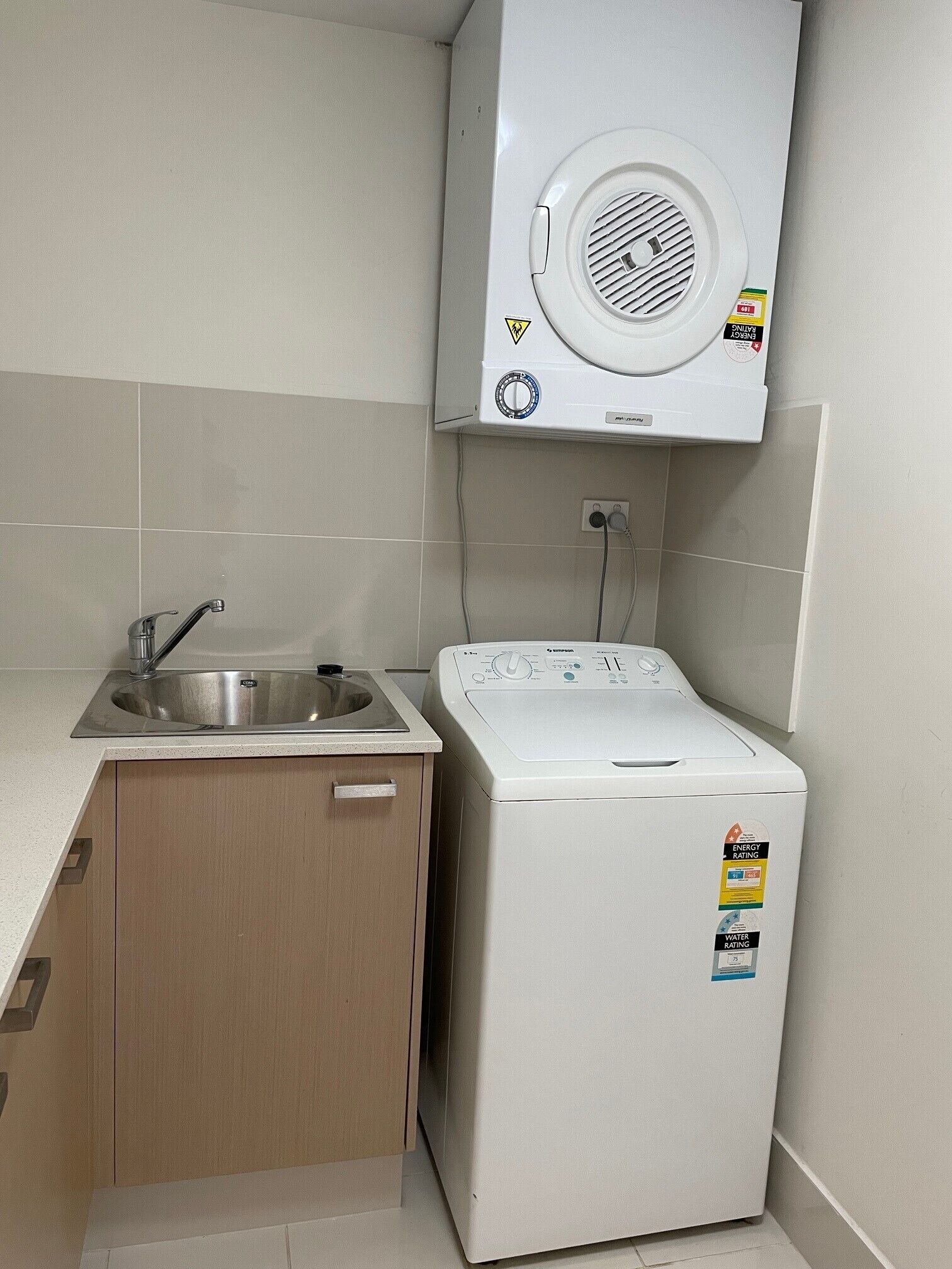 A compact kitchen with a sink, a washing machine, and a built-in dryer.