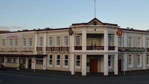 A building with multiple signs including "The Grand Hotel," "Gaming," and "Backpackers Accommodation." - Grand Hotel, Whangarei (Whangarei)