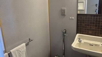 Een kleine badkamer met toilet, wastafel en handdoekhouder.