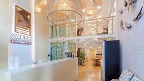 A reception area with a modern design, including a reception desk, a staircase, and a dining area. - Sarnn Sukhumvit 28 (Bangkok)