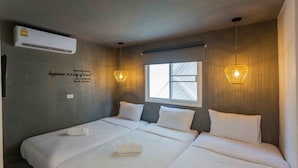 A hotel room with two beds, a window, an air conditioner, and a motivational quote on the wall. - Sarnn Sukhumvit 28 (Bangkok)