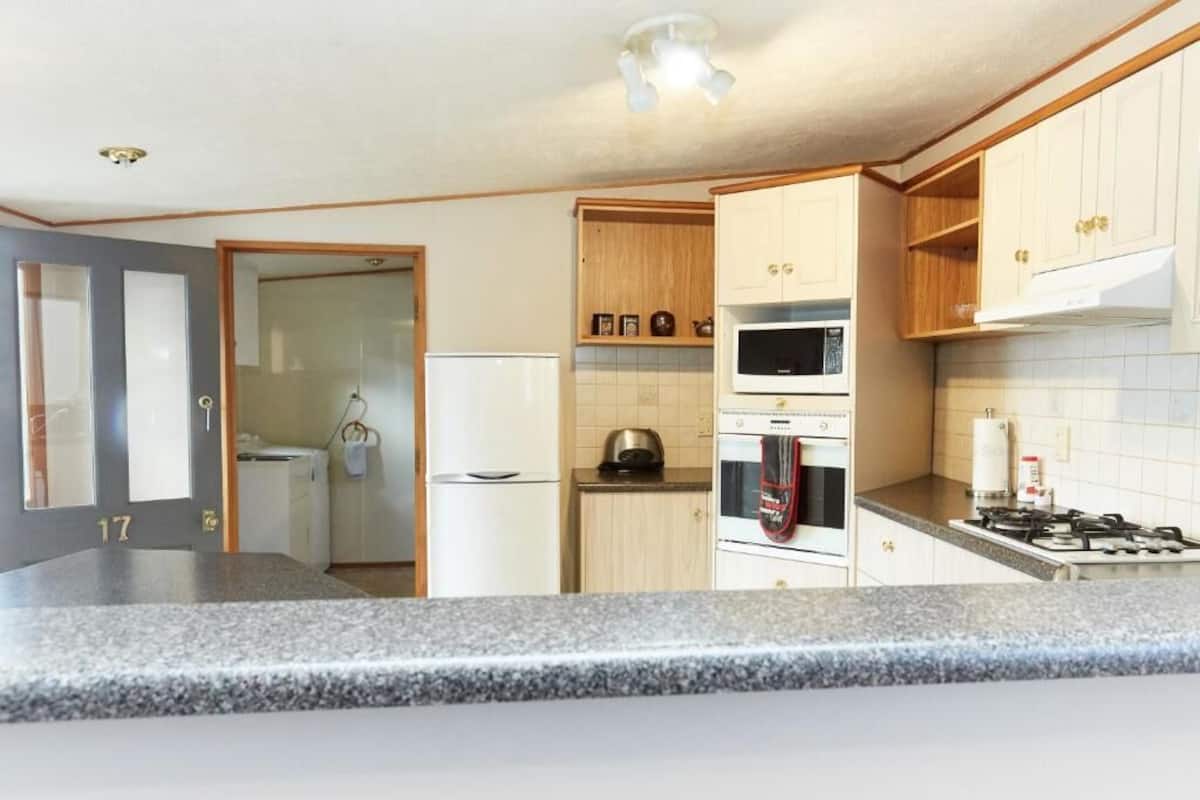 A kitchen with granite countertops, a microwave, oven, and a gas stove.