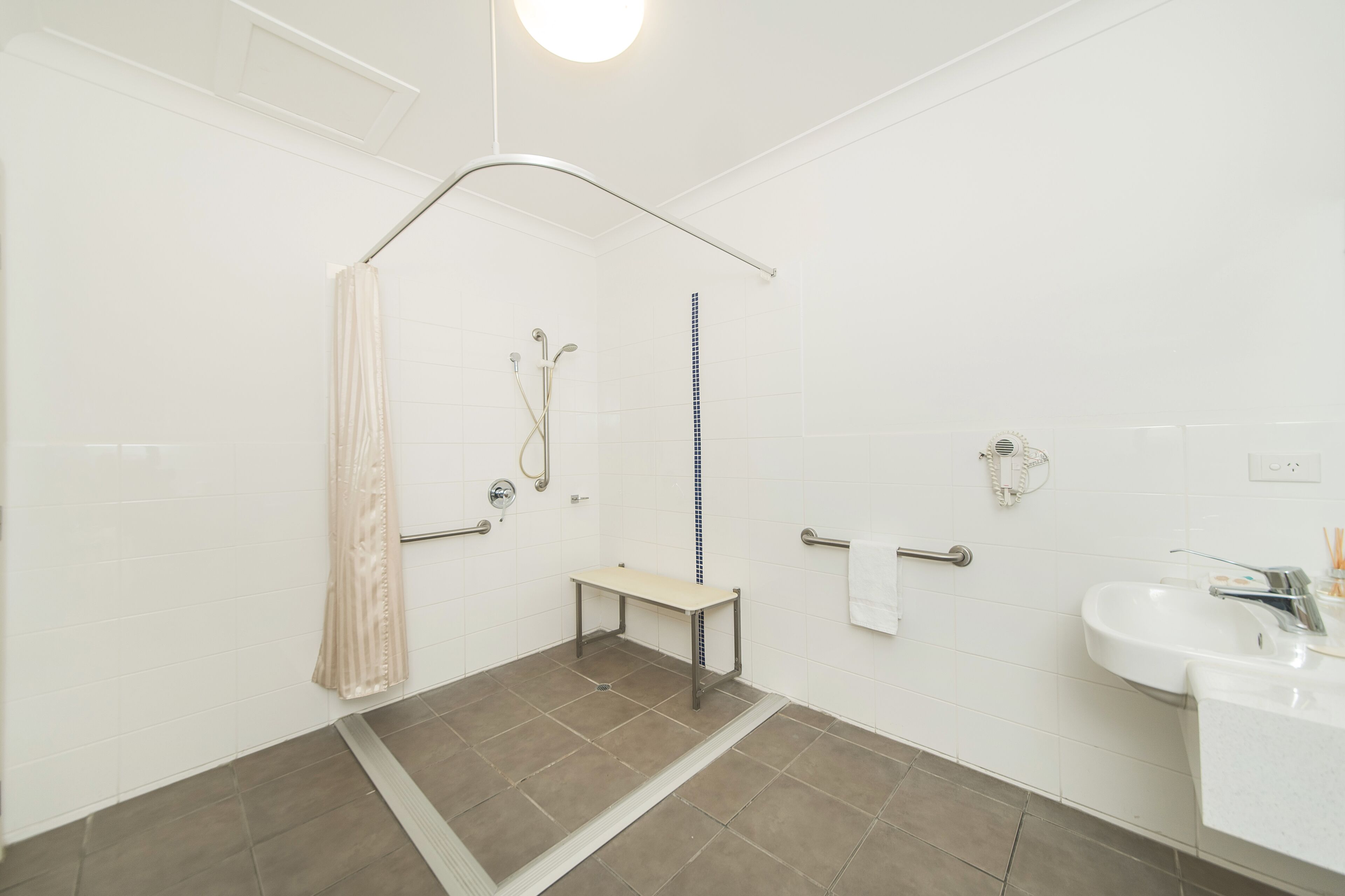 Un baño moderno con ducha, inodoro y lavamanos.