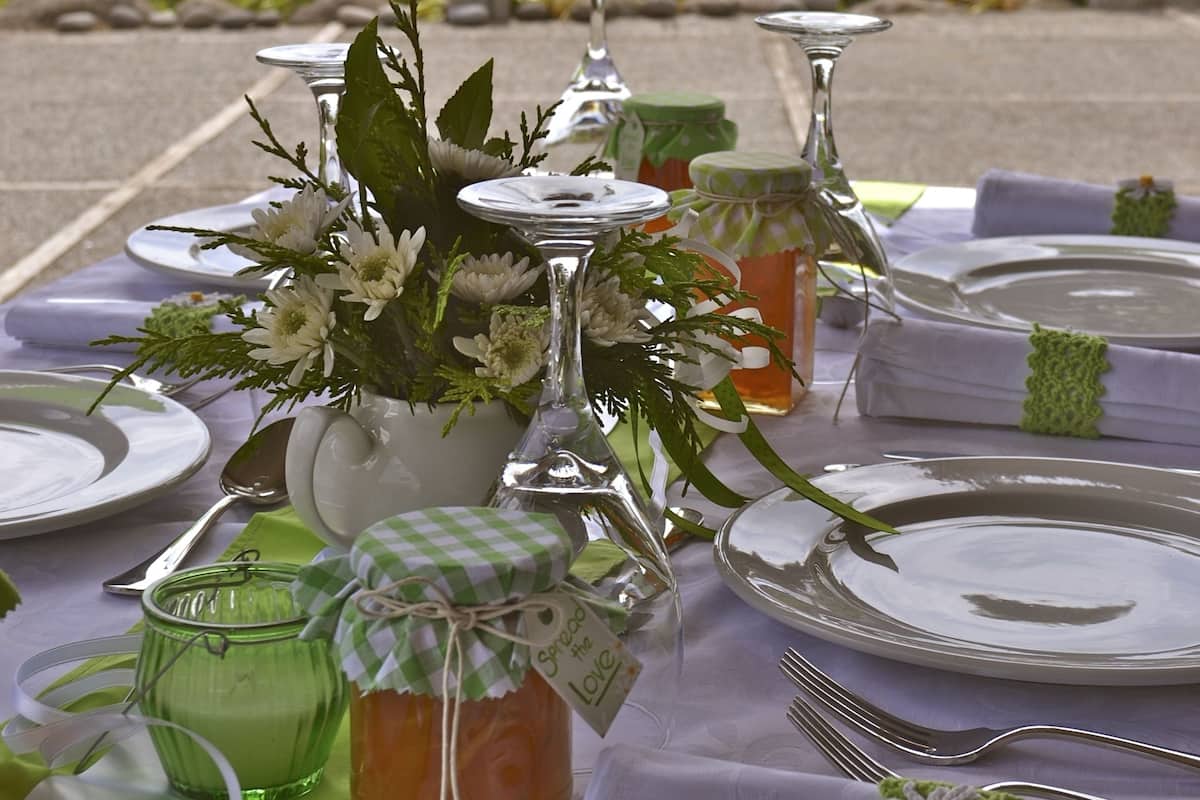 A table set for a meal with a view of the sea and trees in the background.