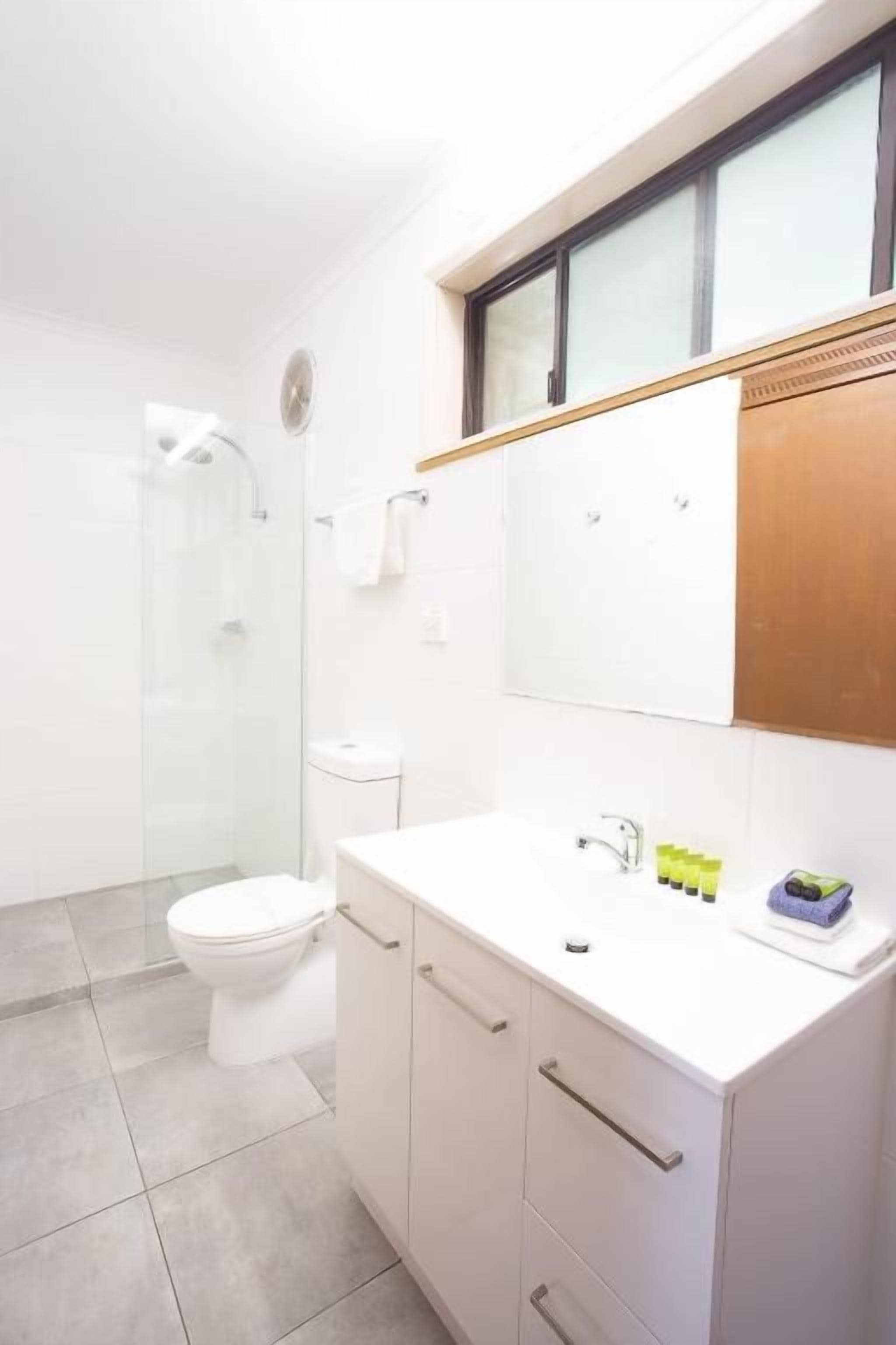 Un baño moderno con inodoro, ducha y lavamanos.