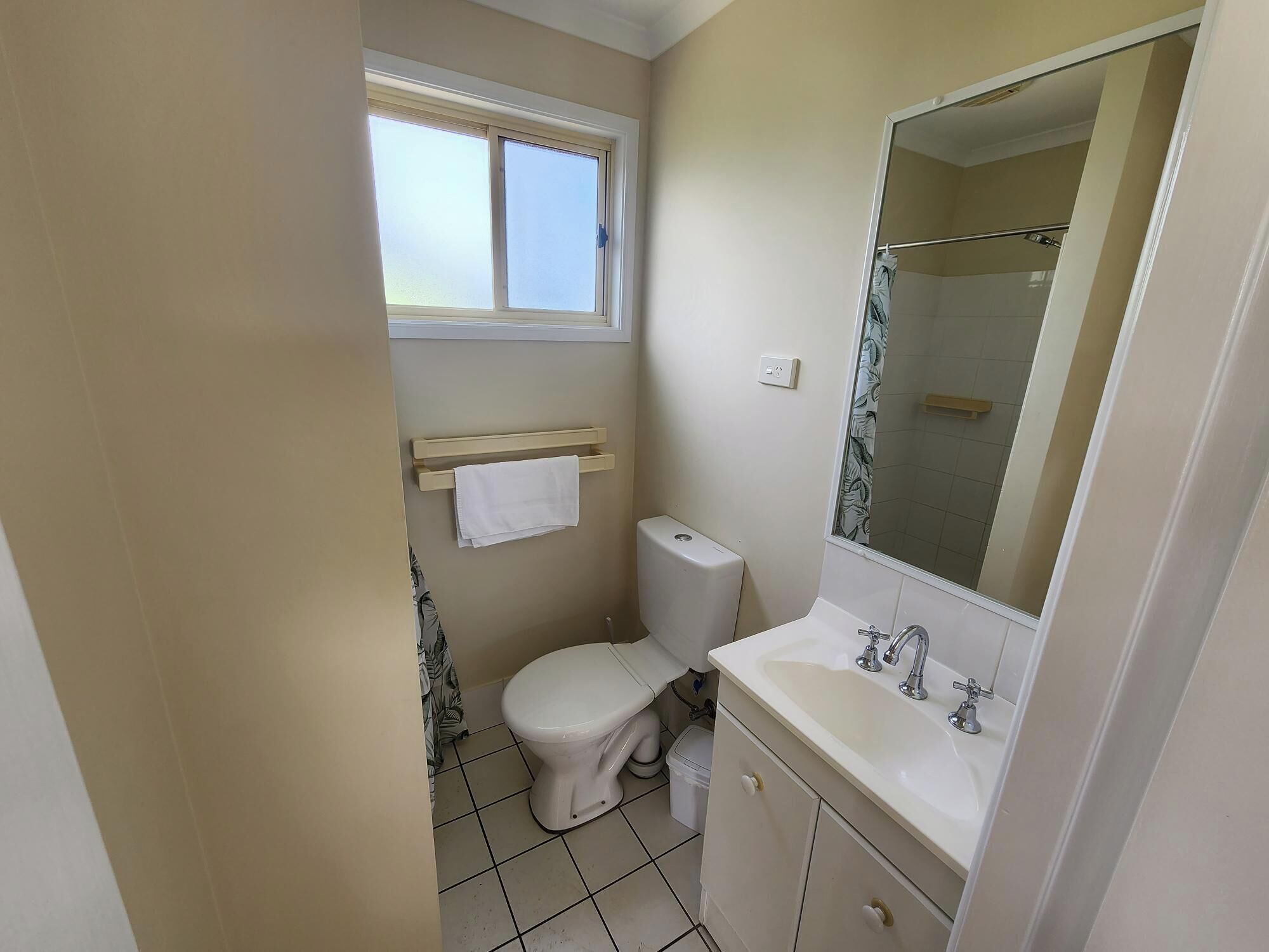 Une petite salle de bain avec des toilettes, un lavabo et un miroir.