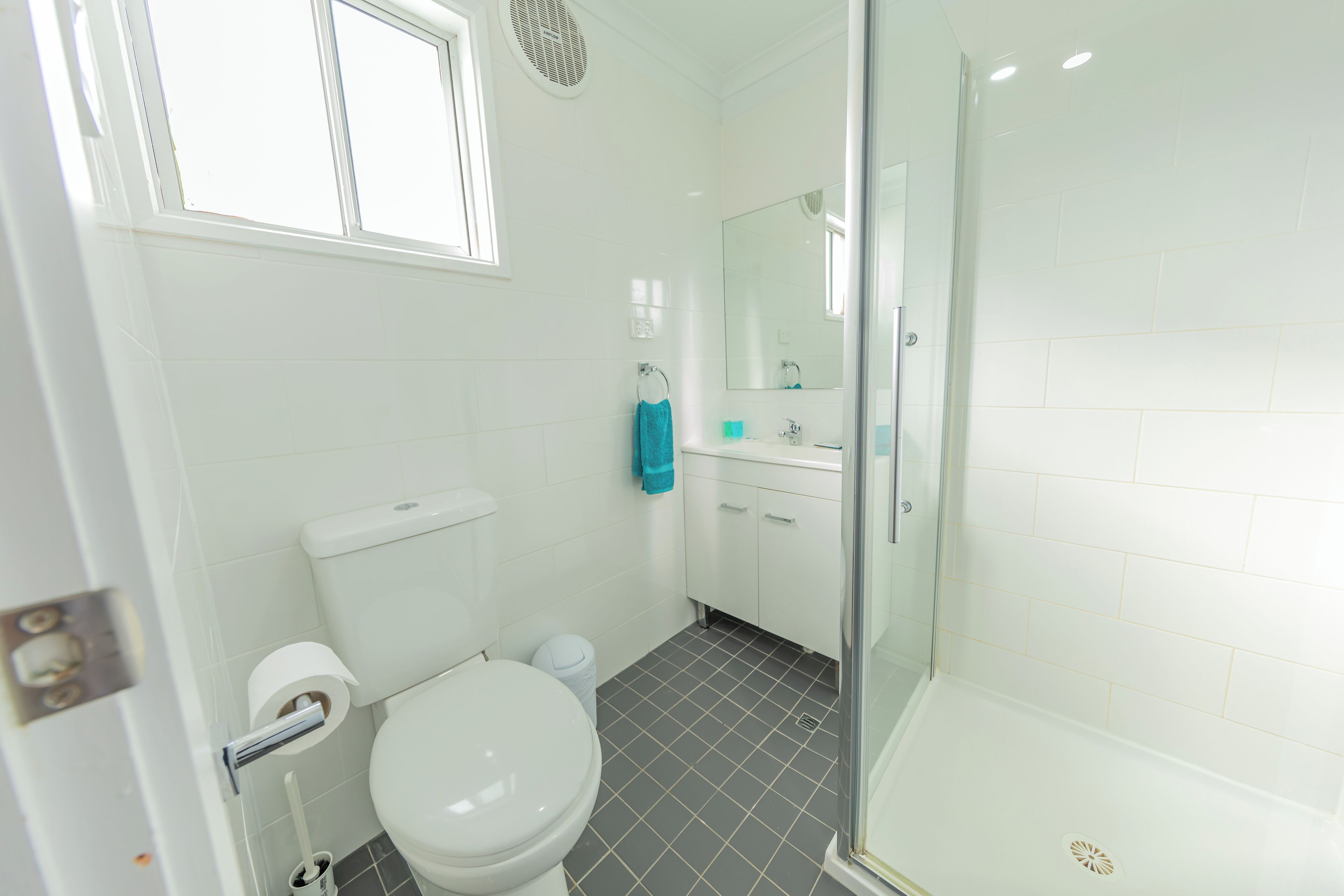 A bathroom with a toilet, sink, and shower.