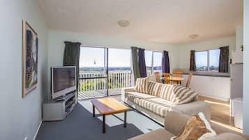 Apartamento panorámico, 1 cama de matrimonio, cocina básica, vistas al mar | Zona de estar | Televisión de pantalla plana de 50 pulgadas con canales por cable