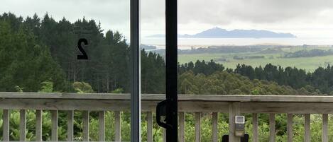 Un balcón con vistas a un área boscosa y montañas distantes.