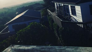 Ein Haus mit schrägem Dach, einem Balkon und Blick auf die umliegende Landschaft.