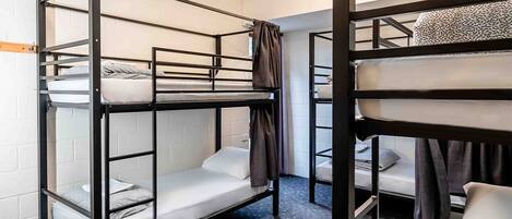 Bunk beds in a room with a carpeted floor and a white brick wall.